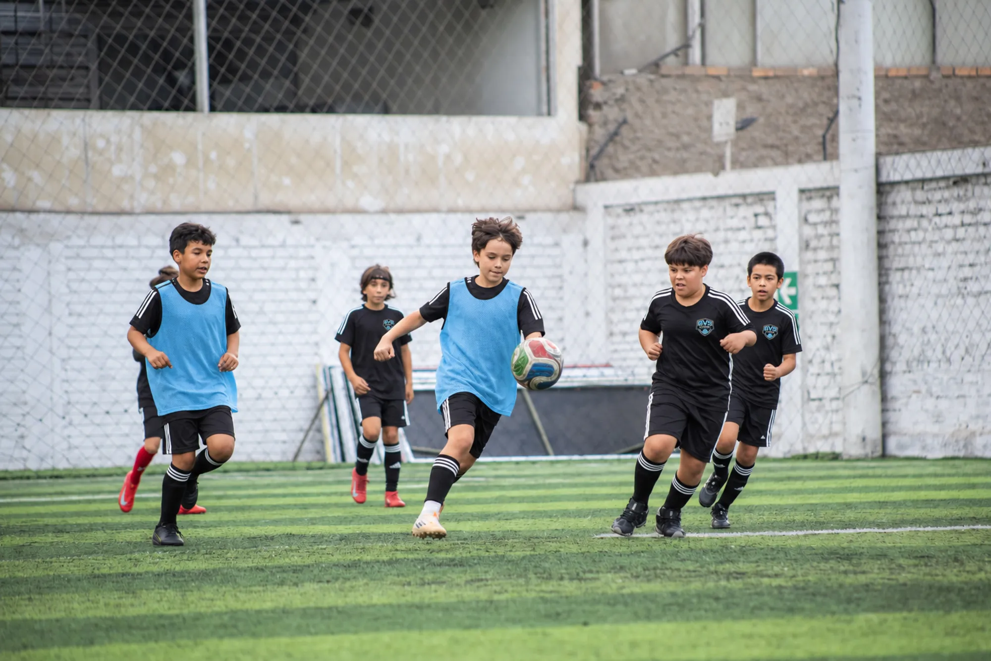 Kids in training bibs running during a soccer session
