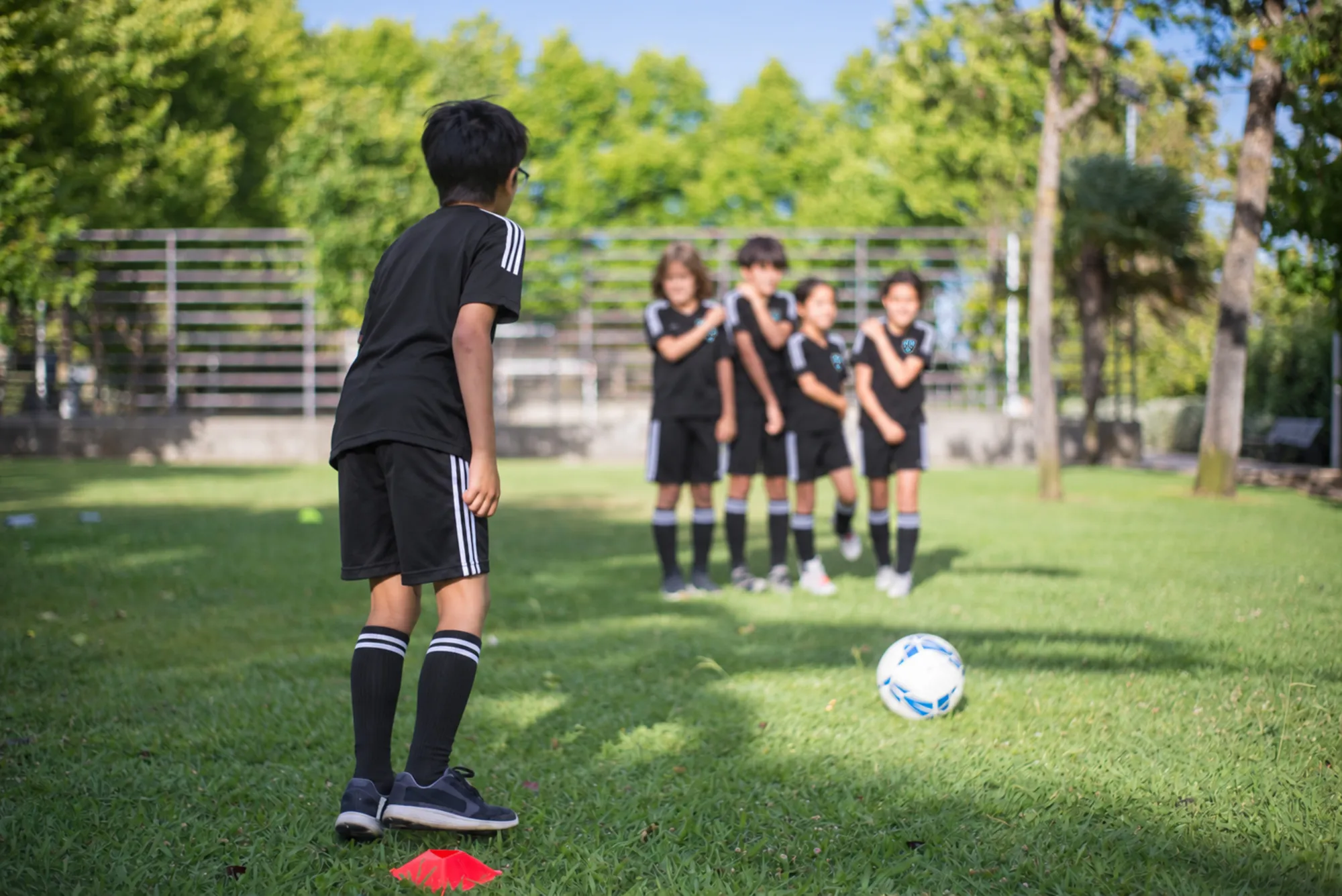 Children playing soccer on a grass field