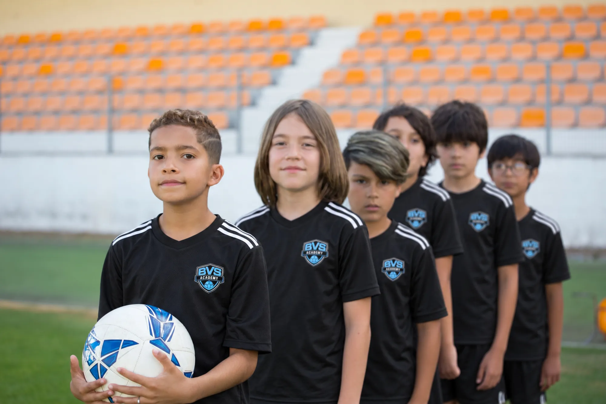 Young players in blue kits lined up on the field